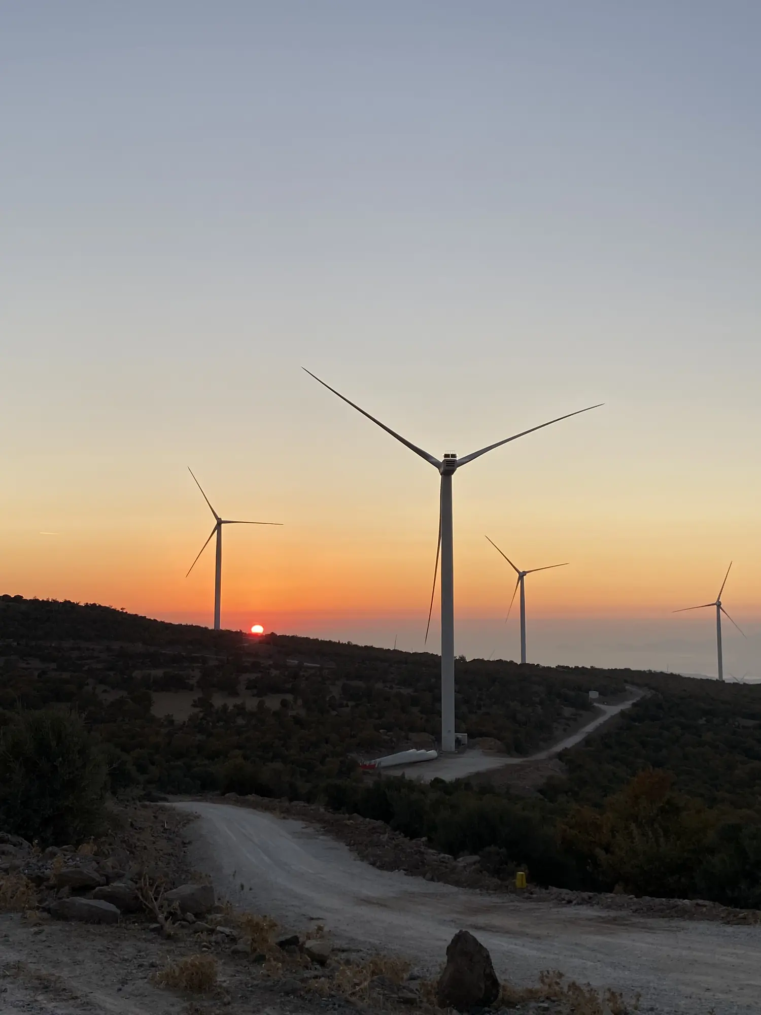 Gün batımında sırt boyunca sıralanmış rüzgâr türbinleri